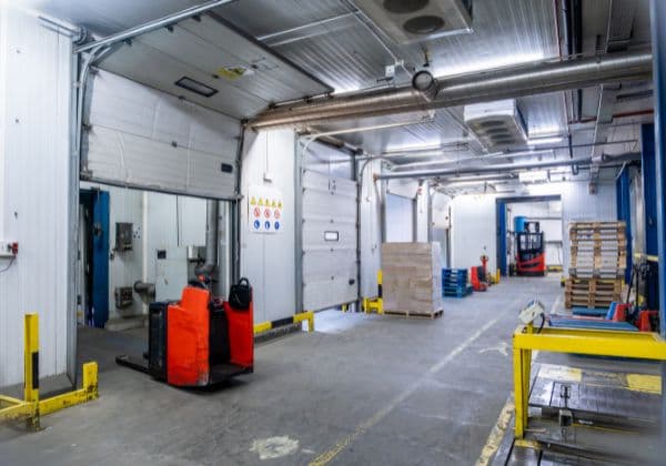 Chilled storage corridor with insulated doors, pallet truck and stacked pallets